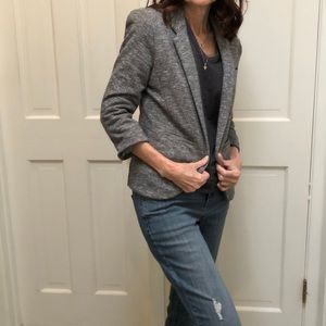 Grey and white jacket. No Button. Two pockets.